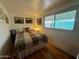 Sunny bedroom features a bed with quilt, wood flooring and a window with natural light at 120 N Val Vista Dr # 151, Mesa, AZ 85213