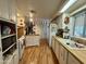 A long galley kitchen features white cabinets and wood floors in this quaint and cozy home at 120 N Val Vista Dr # 151, Mesa, AZ 85213