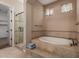 Bathroom showcasing a tiled shower, soaking tub, and a neutral color palette at 1260 E Sweet Citrus Dr, Queen Creek, AZ 85140