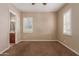 Bedroom showcasing neutral walls, plush carpeting, and an arched entrance leading to the bathroom at 1260 E Sweet Citrus Dr, Queen Creek, AZ 85140