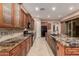 Spacious kitchen featuring granite countertops, dark wood cabinetry, and stainless steel appliances at 1260 E Sweet Citrus Dr, Queen Creek, AZ 85140