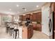 Kitchen island with granite countertop, bar seating, and dark wood cabinets at 1260 E Sweet Citrus Dr, Queen Creek, AZ 85140