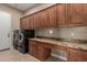 Laundry room featuring modern washer and dryer, ample cabinets, and granite countertops at 1260 E Sweet Citrus Dr, Queen Creek, AZ 85140