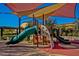Vibrant community playground featuring slides and climbing structures under a shaded canopy at 1260 E Sweet Citrus Dr, Queen Creek, AZ 85140