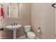 Comfortable half bath features a pedestal sink and neutral color palette at 1260 E Sweet Citrus Dr, Queen Creek, AZ 85140