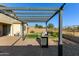 Backyard patio featuring a pergola, barbeque, pavers, and green grass against a blue sky at 1277 W Stephanie Ln, San Tan Valley, AZ 85143