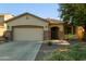 Home exterior with a two-car garage, decorative stone accents, and desert landscaping at 1277 W Stephanie Ln, San Tan Valley, AZ 85143