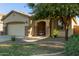 Front exterior with a well-manicured lawn, desert landscaping, and covered porch with seating at 1277 W Stephanie Ln, San Tan Valley, AZ 85143