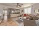 Open-concept living room with tile floors, a ceiling fan, large windows, and seamless access to the modern kitchen at 1277 W Stephanie Ln, San Tan Valley, AZ 85143