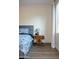Bedroom featuring a wooden nightstand with a stylish grey lamp and plank accent wall at 12934 W Chapala Dr, Sun City West, AZ 85375