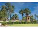 Gated community entrance with mature trees and manicured landscaping at 12934 W Chapala Dr, Sun City West, AZ 85375