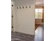 Hallway with a shiplap accent wall with hooks and a view into the adjacent bedroom at 12934 W Chapala Dr, Sun City West, AZ 85375