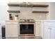 The kitchen features stainless steel stove, floating shelves, white cabinets and quartz countertops at 12934 W Chapala Dr, Sun City West, AZ 85375