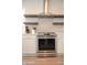 Kitchen featuring stainless steel stove, floating shelves, white cabinets and quartz countertops at 12934 W Chapala Dr, Sun City West, AZ 85375