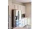 Kitchen includes stainless steel refrigerator, white cabinets and countertops, and luxury vinyl flooring at 12934 W Chapala Dr, Sun City West, AZ 85375
