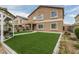 The backyard has synthetic grass, pavers, and a covered outdoor seating area at 14318 N 142Nd Ln, Surprise, AZ 85379