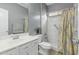 Well-lit bathroom features white tiled shower with patterned curtain, and large vanity with drawers at 14318 N 142Nd Ln, Surprise, AZ 85379