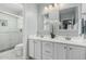 Elegant bathroom featuring a double vanity, stylish mirrors, and a walk-in shower with tile surround at 14318 N 142Nd Ln, Surprise, AZ 85379
