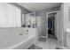 Bathroom view with large tub, glass shower, and walk-in closet for extra storage at 14318 N 142Nd Ln, Surprise, AZ 85379