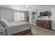 Bedroom boasting a ceiling fan, large windows, and dresser with convenient bathroom access at 14318 N 142Nd Ln, Surprise, AZ 85379