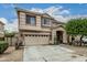 Charming two-story home featuring a well-manicured lawn, a two-car garage, and a welcoming entryway at 14318 N 142Nd Ln, Surprise, AZ 85379