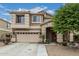 Charming two-story home featuring a well-manicured lawn, a two-car garage, and a welcoming entryway at 14318 N 142Nd Ln, Surprise, AZ 85379