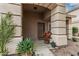 Inviting front porch with decorative plants and a textured archway, offering a warm welcome at 14318 N 142Nd Ln, Surprise, AZ 85379