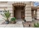 Inviting front porch with decorative plants and a textured archway, offering a warm welcome at 14318 N 142Nd Ln, Surprise, AZ 85379