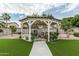 Charming gazebo with outdoor seating, lush plants, and a view of the backyard's artificial turf at 14318 N 142Nd Ln, Surprise, AZ 85379