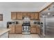 Close-up of kitchen features stainless steel range and refrigerator, light cabinets, and tiled backsplash at 14318 N 142Nd Ln, Surprise, AZ 85379