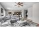 Open-concept living room offers modern furniture, a ceiling fan, and seamless flow to other areas at 14318 N 142Nd Ln, Surprise, AZ 85379
