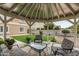 Relaxing covered patio with comfortable seating and view of the manicured backyard and grassy lawn at 14318 N 142Nd Ln, Surprise, AZ 85379