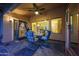 Relaxing covered patio features stylish seating, a ceiling fan, and views of the spacious backyard at 15245 W Crocus Dr, Surprise, AZ 85379