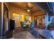 Inviting covered patio area with stylish seating, a ceiling fan, and views of the backyard at 15245 W Crocus Dr, Surprise, AZ 85379