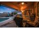 Charming backyard with a covered patio, outdoor kitchen, a refreshing pool, and comfortable seating at 15245 W Crocus Dr, Surprise, AZ 85379