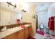 Bathroom with double sinks, decorative mirror, and separate toilet area at 15245 W Crocus Dr, Surprise, AZ 85379