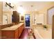 Bathroom featuring dual sinks, granite countertops, a walk-in closet and a separate shower and bathtub at 15245 W Crocus Dr, Surprise, AZ 85379