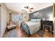 Cozy bedroom with wood flooring, a ceiling fan, and a full bed at 15245 W Crocus Dr, Surprise, AZ 85379