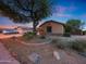 Landscaped front yard with desert plants, a large shade tree, and a stone-accented exterior at 15245 W Crocus Dr, Surprise, AZ 85379
