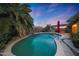 Sparkling backyard pool featuring a lush tropical palm tree and water feature creating an oasis at 15245 W Crocus Dr, Surprise, AZ 85379