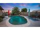 Inviting pool featuring stone accents, palm tree, and colorful patio furniture, perfect for backyard relaxation at 15245 W Crocus Dr, Surprise, AZ 85379