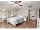 Bright bedroom featuring wood floors, a ceiling fan, and mirrored closet doors at 15424 N 52Nd Pl, Scottsdale, AZ 85254