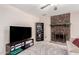 Open concept living room featuring ceiling fan, stone fireplace, and entertainment center at 15424 N 52Nd Pl, Scottsdale, AZ 85254