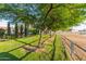 Expansive backyard with mature trees and a partial view of fenced pasture. Horse property at 15602 N 37Th St, Phoenix, AZ 85032