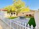 Quaint backyard featuring a patio area with seating, artificial grass, and a white picket fence at 15602 N 37Th St, Phoenix, AZ 85032