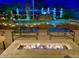 Cozy backyard featuring a fire pit, tables and pool with waterfall feature and landscape lighting at 15602 N 37Th St, Phoenix, AZ 85032