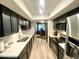 Galley kitchen featuring black cabinetry, stainless steel appliances, and light, neutral-toned floors at 15602 N 37Th St, Phoenix, AZ 85032
