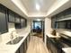 Galley kitchen featuring black cabinetry, stainless steel appliances, and light, neutral-toned floors at 15602 N 37Th St, Phoenix, AZ 85032