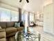 View of open-plan living room featuring couch, coffee table, kitchen, and ample natural light at 15602 N 37Th St, Phoenix, AZ 85032