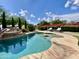 Backyard pool with rock waterfall, lush landscaping, and sun loungers at 15602 N 37Th St, Phoenix, AZ 85032